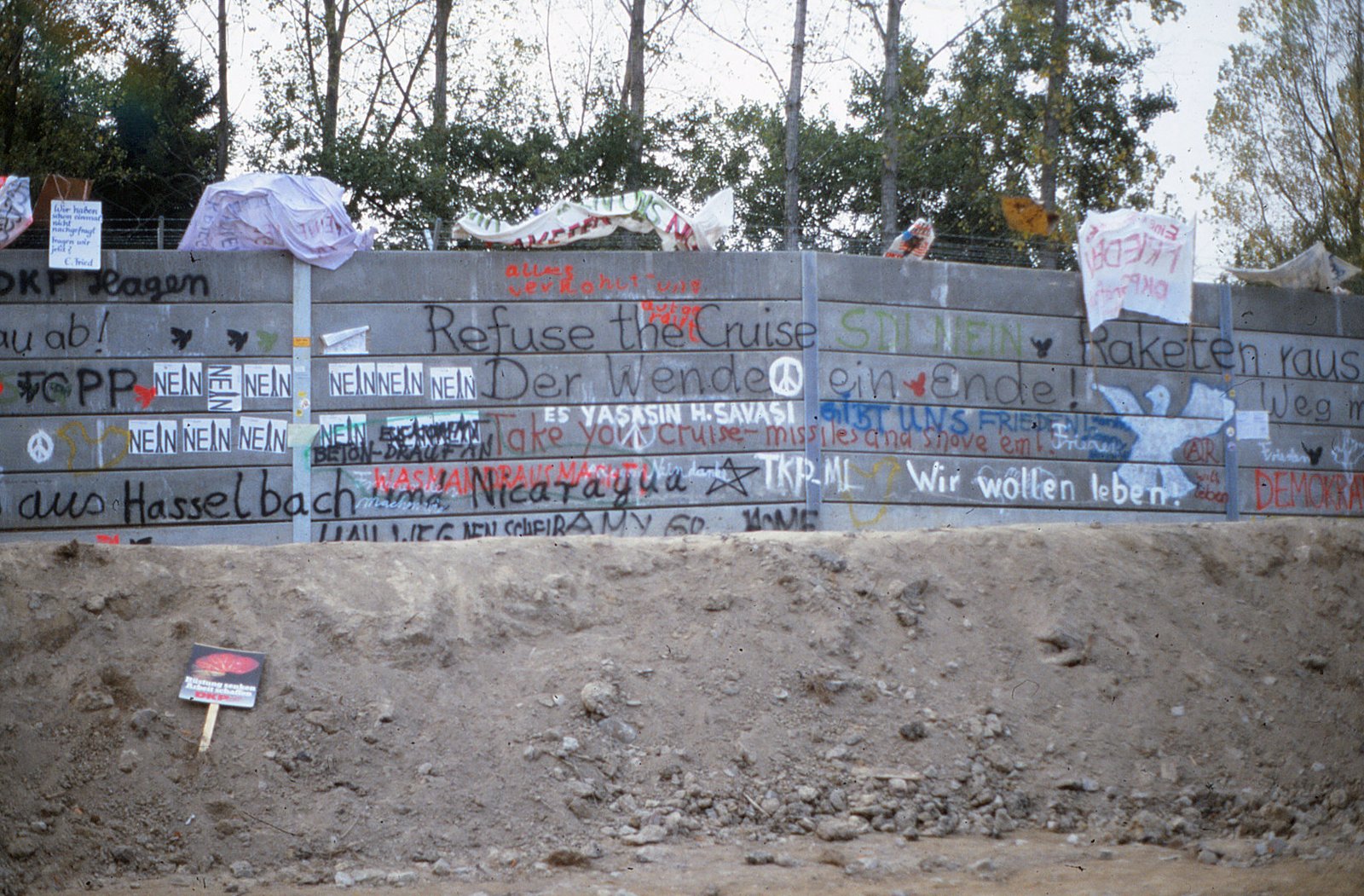 Beschriftete Betonmauer mit Parolen in mehreren Sprachen